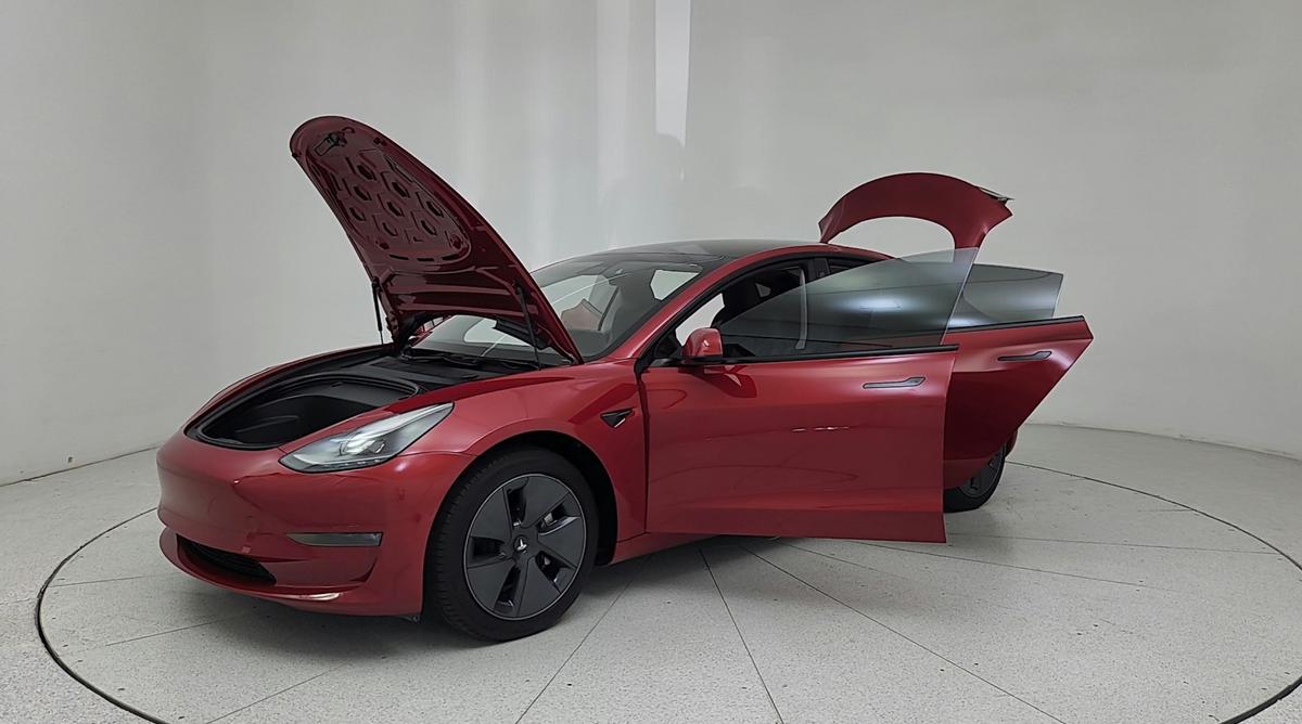 A sleek used Tesla Model 3 parked against an urban backdrop, symbolizing the blend of affordability and innovation.