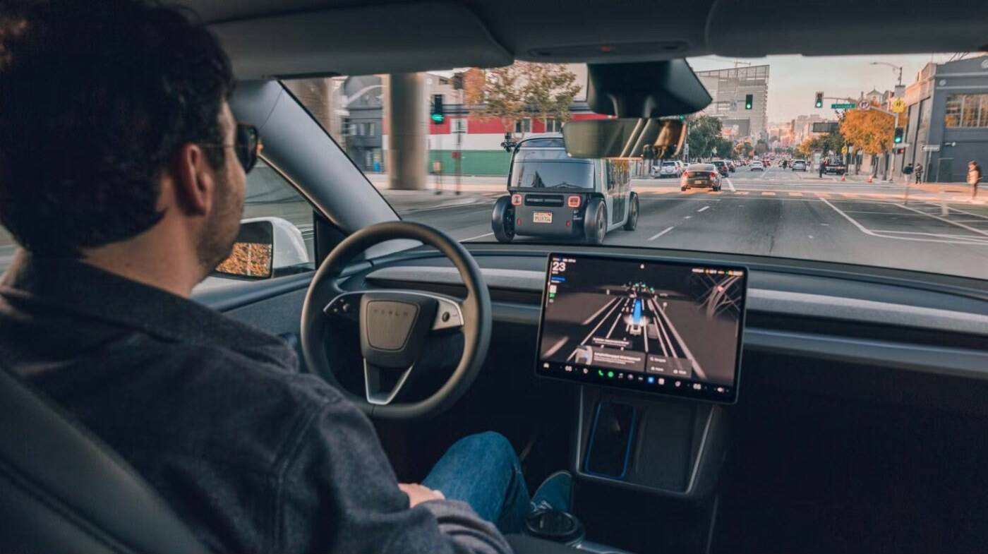 A driver using the Tesla center screen on a city street